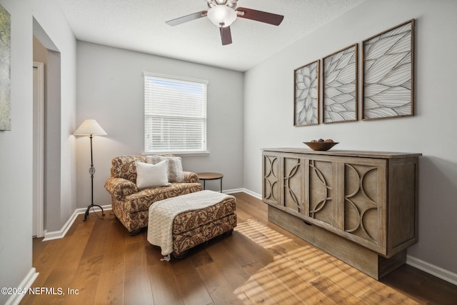 sitting room with hardwood / wood-style flooring, a textured ceiling, and ceiling fan