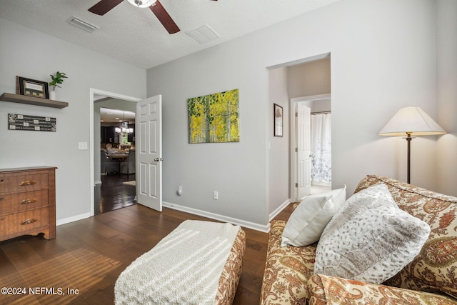 bedroom with ceiling fan, dark hardwood / wood-style floors, and a textured ceiling