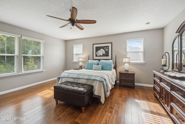 bedroom featuring dark wood-type flooring, ceiling fan, and a textured ceiling