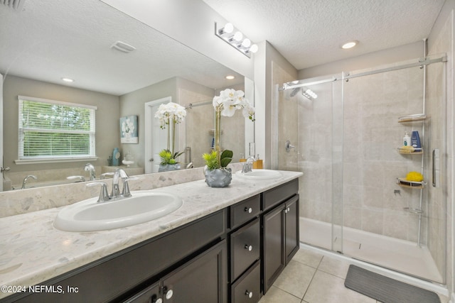 bathroom featuring vanity, a shower with door, tile patterned flooring, and a textured ceiling