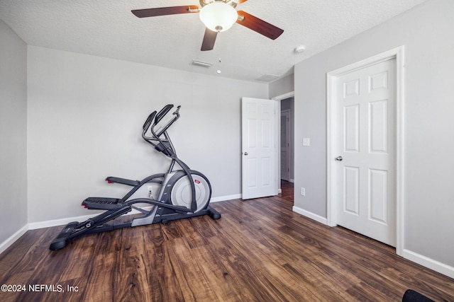 workout area featuring dark wood-type flooring and a textured ceiling