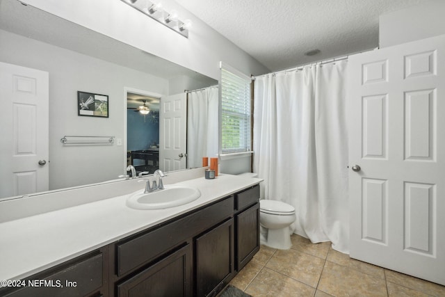 bathroom with vanity, toilet, tile patterned flooring, and a textured ceiling