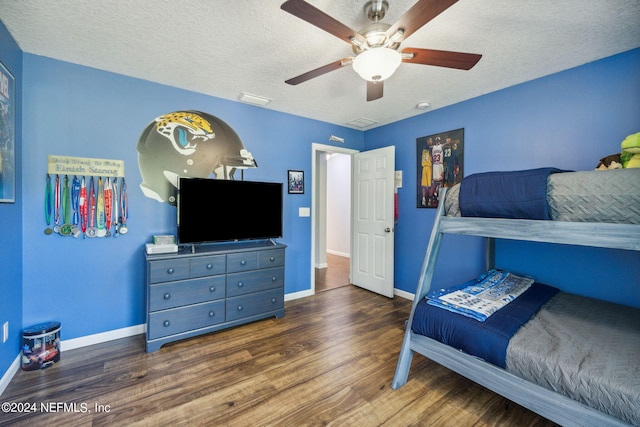 bedroom with dark wood-type flooring, ceiling fan, and a textured ceiling