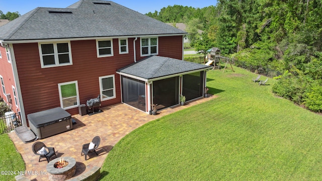 rear view of house with a sunroom, a lawn, a playground, a fire pit, and a patio