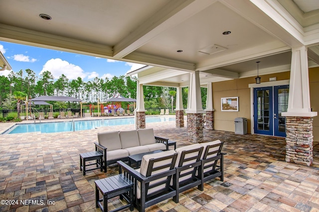 view of patio with french doors, a community pool, and outdoor lounge area