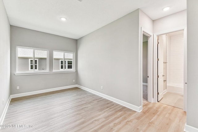 unfurnished room featuring light wood-style flooring and baseboards