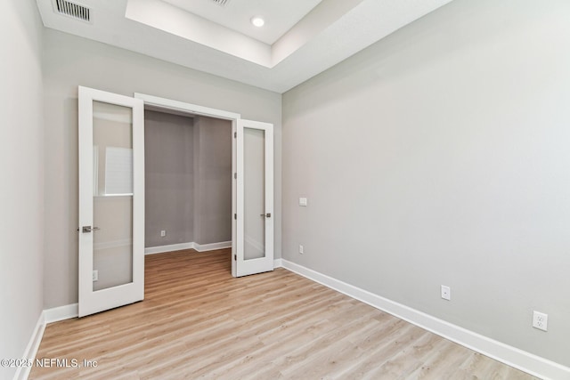 unfurnished bedroom with light wood-type flooring, visible vents, baseboards, and french doors