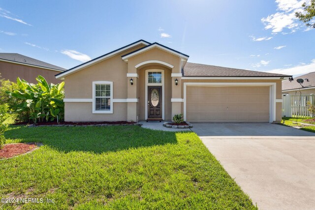 single story home featuring a garage and a front lawn