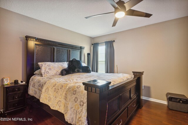 bedroom with dark wood-type flooring, a textured ceiling, and ceiling fan