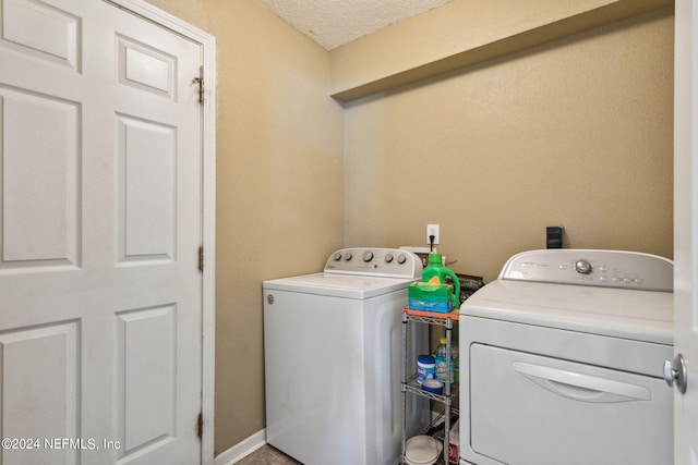 laundry area featuring washer and clothes dryer and a textured ceiling