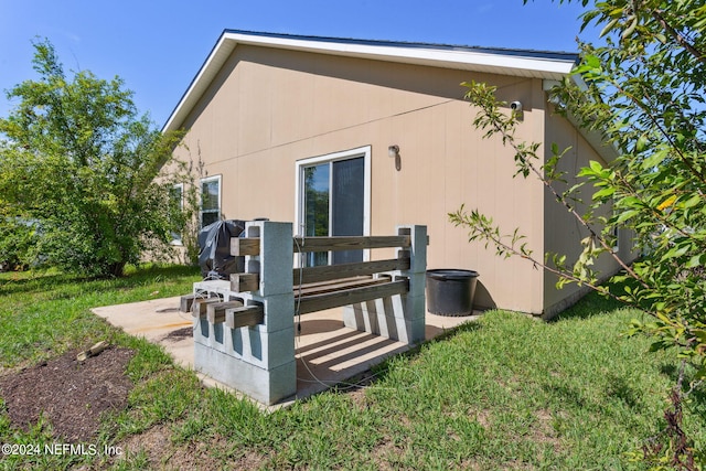 back of property featuring a patio and a yard