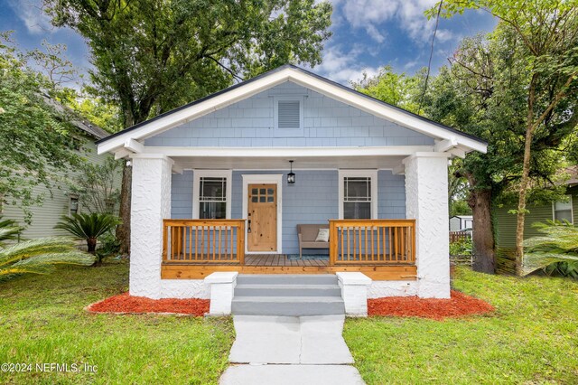 bungalow-style house featuring a porch and a front lawn