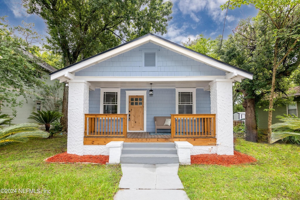 bungalow-style house featuring a porch and a front lawn