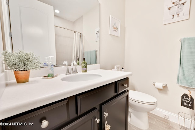 bathroom with walk in shower, vanity, and toilet