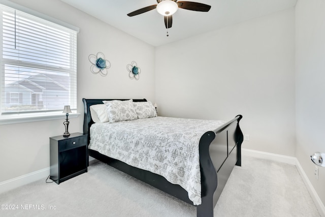 bedroom featuring ceiling fan, multiple windows, and light carpet