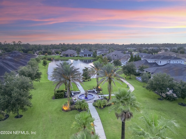 aerial view at dusk featuring a water view