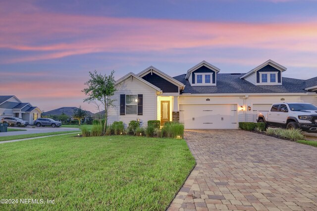 view of front of home with a yard and a garage