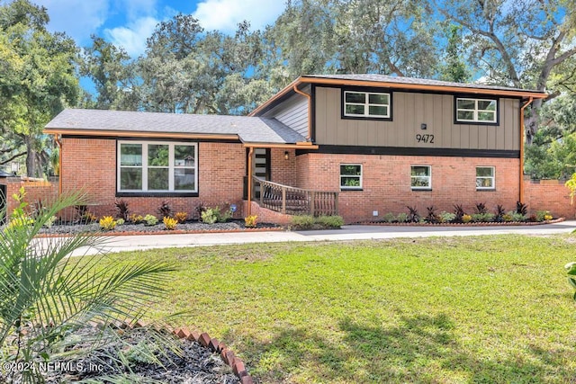 tri-level home with a front lawn