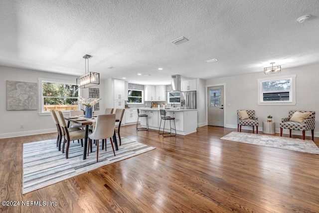 dining space featuring a textured ceiling, a chandelier, and dark hardwood / wood-style flooring