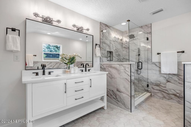 bathroom featuring vanity, a textured ceiling, an enclosed shower, and tile patterned flooring