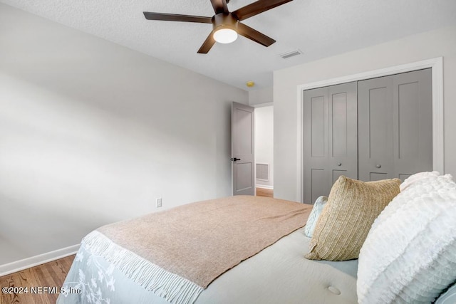 bedroom with a closet, wood-type flooring, and ceiling fan