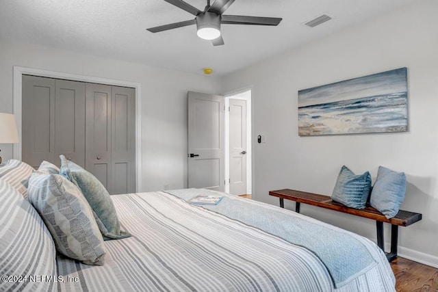 bedroom with a closet, ceiling fan, and dark hardwood / wood-style floors