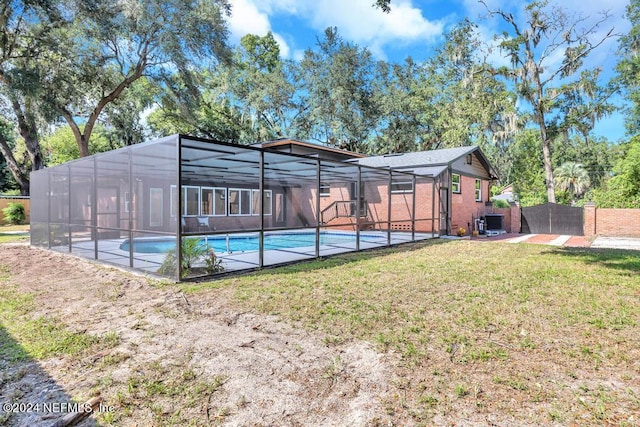 view of pool with a lawn and glass enclosure