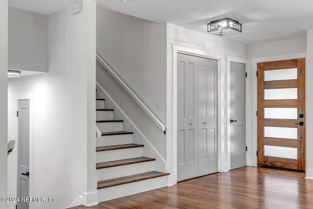 foyer entrance with a textured ceiling and hardwood / wood-style flooring