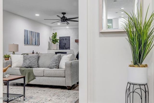 living room featuring hardwood / wood-style floors and ceiling fan