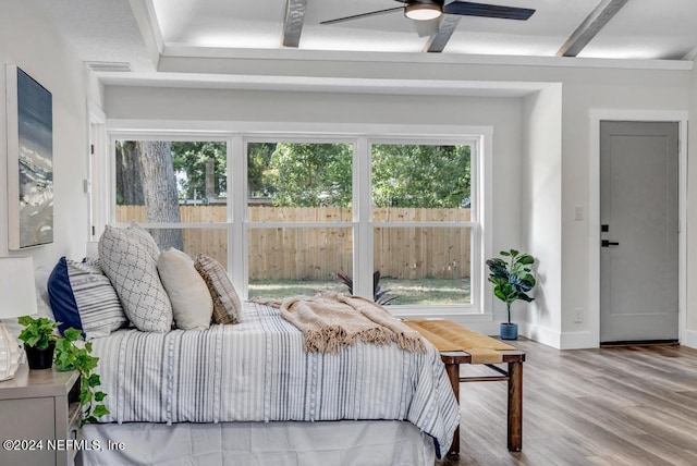 bedroom featuring hardwood / wood-style floors, ceiling fan, and beamed ceiling