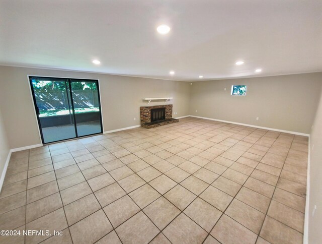 unfurnished living room with a fireplace and light tile patterned flooring