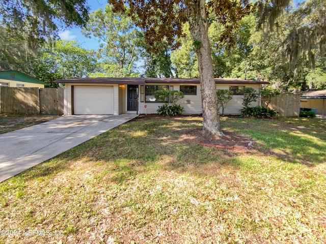 ranch-style home with a garage and a front lawn