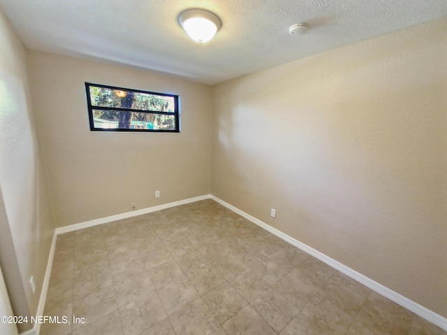 spare room with a textured ceiling