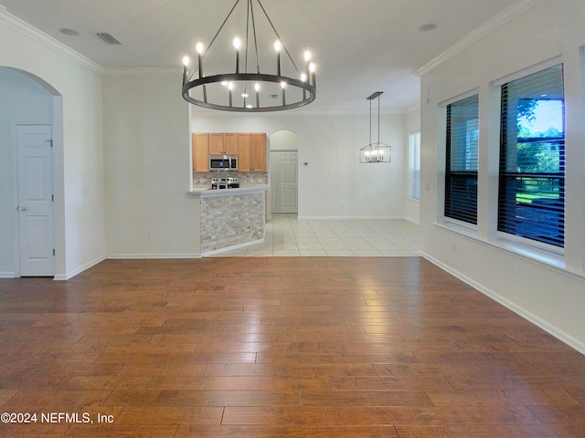 unfurnished living room featuring ornamental molding, a notable chandelier, and light tile patterned floors