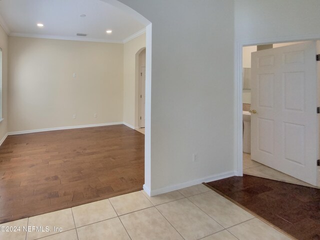 empty room featuring light hardwood / wood-style flooring and crown molding