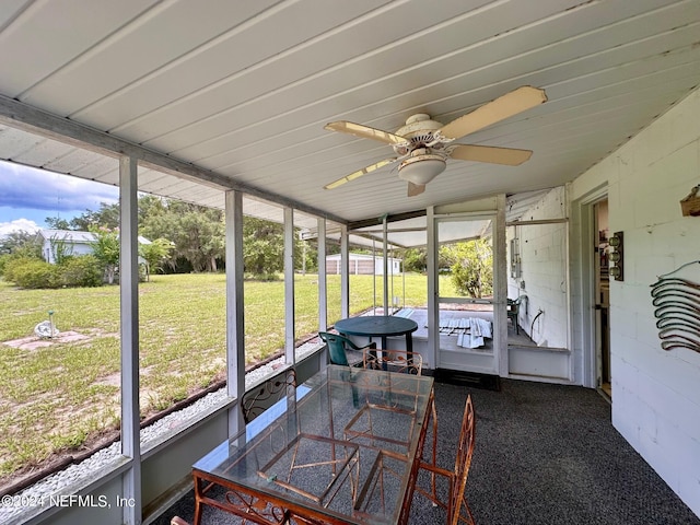 sunroom featuring ceiling fan and vaulted ceiling