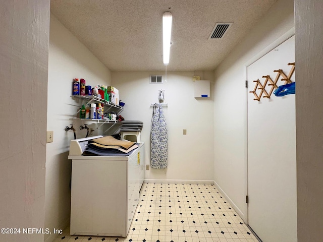 laundry room with washing machine and dryer and a textured ceiling