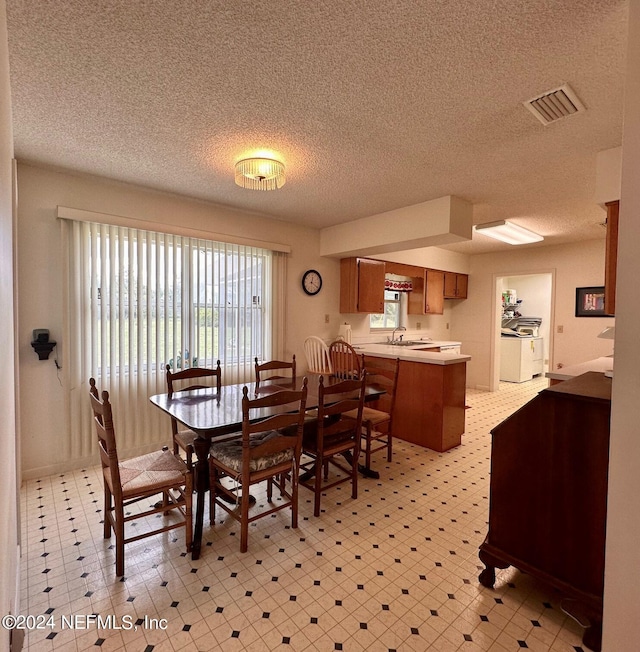 dining space with sink and a textured ceiling