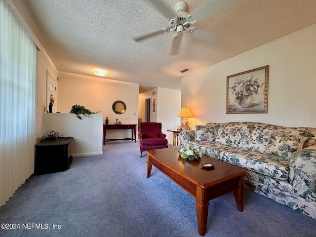 living room featuring carpet, a textured ceiling, and ceiling fan