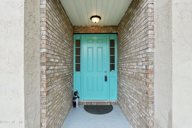 entrance to property with stucco siding and brick siding