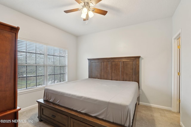 bedroom featuring light colored carpet, ceiling fan, and baseboards