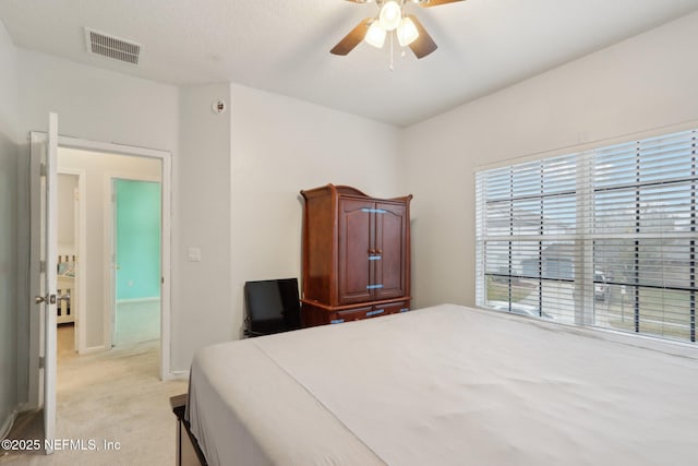 bedroom featuring ceiling fan, visible vents, and light colored carpet