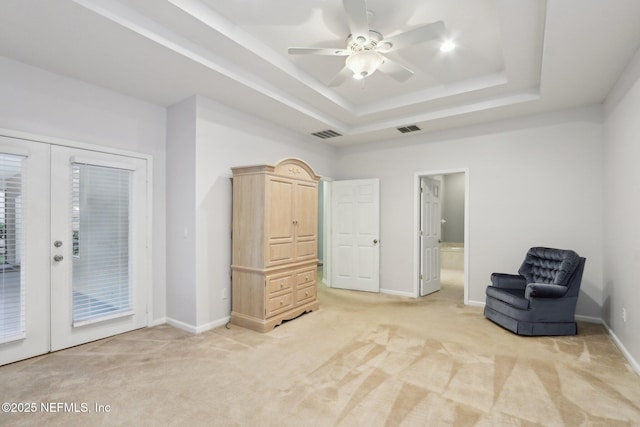 unfurnished room featuring light carpet, french doors, a tray ceiling, and visible vents