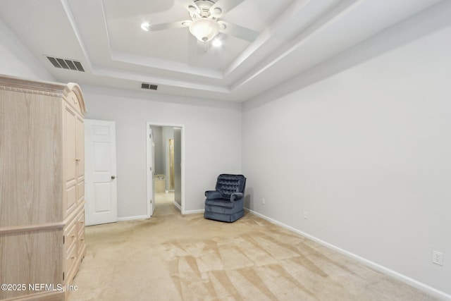 unfurnished room featuring baseboards, a tray ceiling, visible vents, and light colored carpet