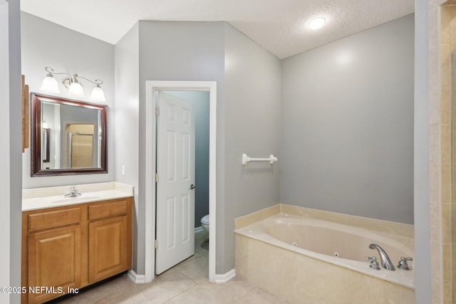 bathroom with toilet, tile patterned flooring, a textured ceiling, vanity, and a bath