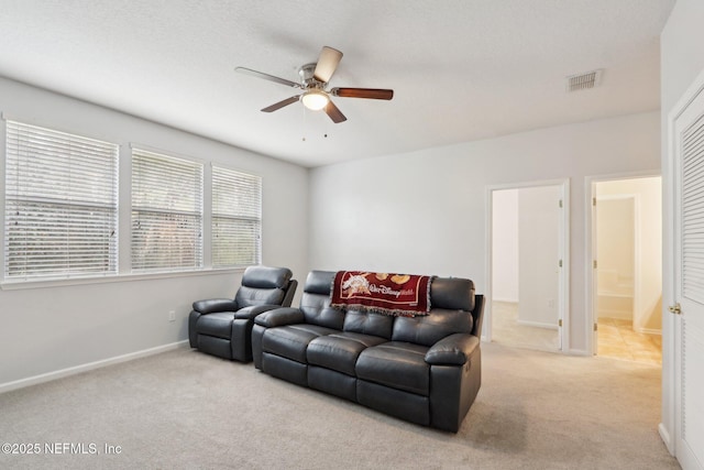 living room featuring light carpet, baseboards, visible vents, and a ceiling fan