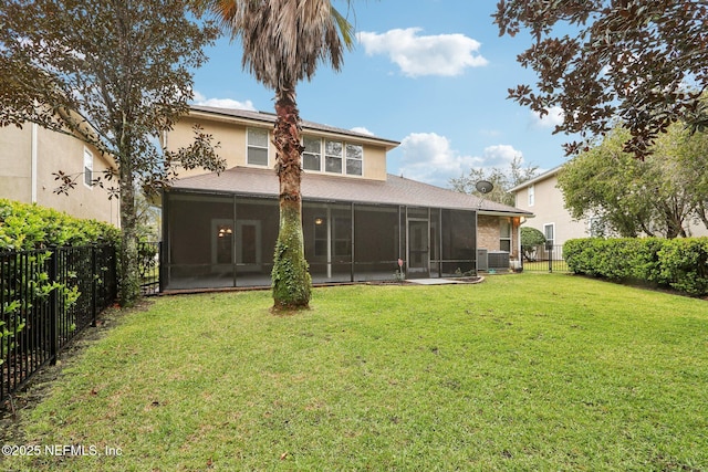 back of property with a sunroom, a fenced backyard, a lawn, and stucco siding