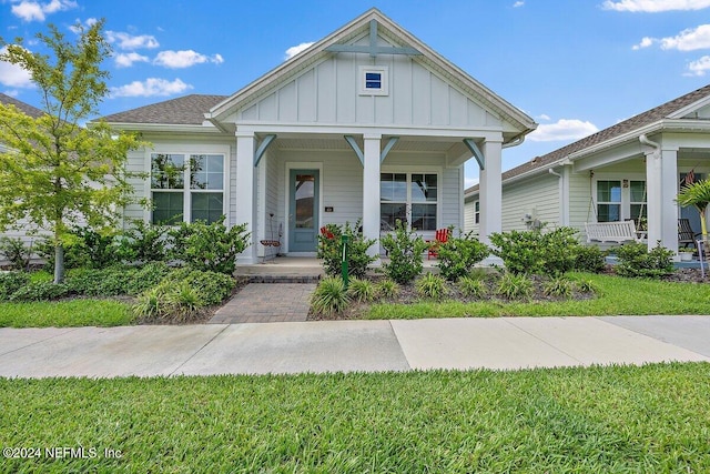 view of front of home with covered porch and a front lawn