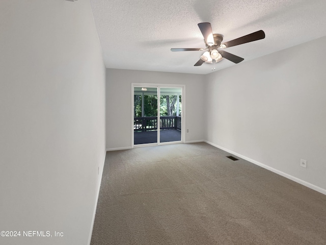 empty room with ceiling fan, carpet flooring, and a textured ceiling