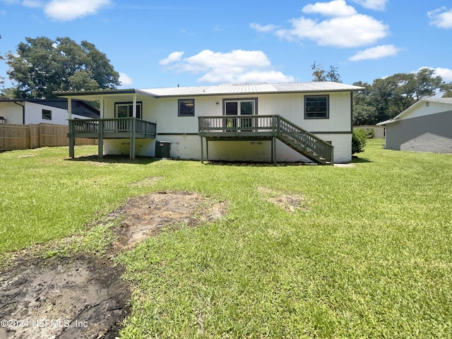 back of house with a wooden deck and a yard